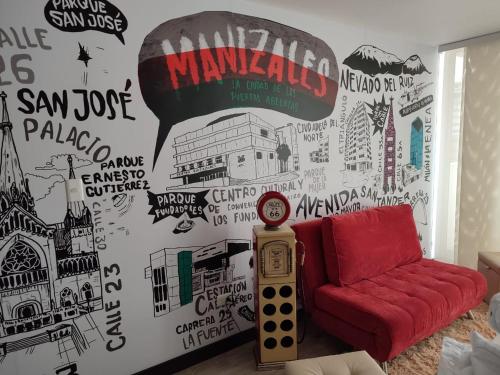 ein Wohnzimmer mit einem roten Sofa und einem Wandbild in der Unterkunft Apartamento céntrico en Manizales, costo por noche $125.000 in Manizales