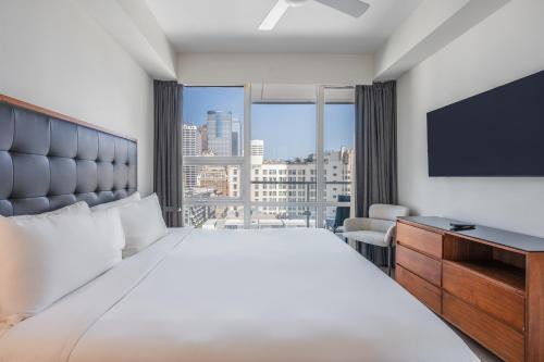 a hotel room with a large bed and a large window at Level Los Angeles - Downtown South Olive in Los Angeles