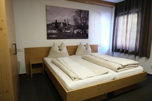 Bett in einem Zimmer mit einem Bild an der Wand in der Unterkunft "beim Butz" in Wörth an der Donau