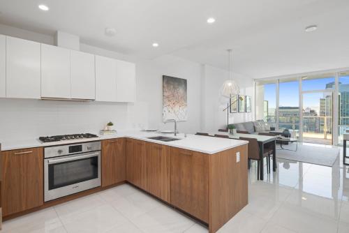 a kitchen with white walls and wooden cabinets and a table at Level Los Angeles - Downtown South Olive in Los Angeles