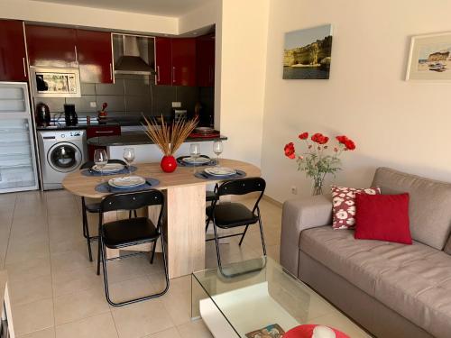 eine Küche und ein Wohnzimmer mit einem Tisch und einem Sofa in der Unterkunft Ver-O-Mar in Carvoeiro