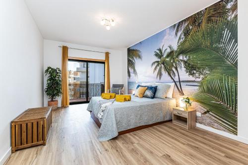 a bedroom with a bed and a palm tree mural at Dream Nest in Armação de Pêra