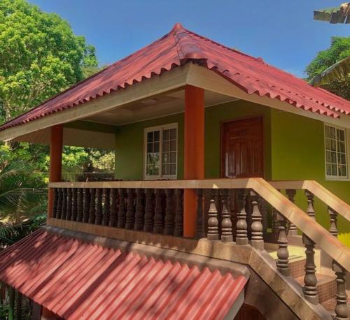 uma pequena casa verde com um telhado vermelho em Hostal Familiar Rolo em Santa Catalina