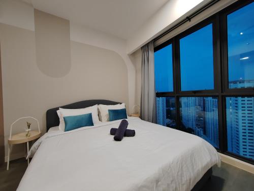 een slaapkamer met een wit bed en een groot raam bij The Ooak Suites @ 163 Building (Mont Kiara) in Kuala Lumpur