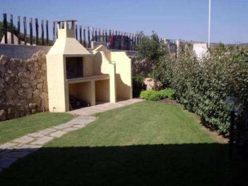 un piccolo giardino con un muro in pietra e un cortile di Vittorio house -Villetta indipendente - Villasimius a Villasimius