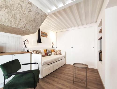 une chambre avec un lit et une chaise dans une pièce dans l'établissement Studio aux Arceaux, sur jardin, dans maison 1900, à Montpellier