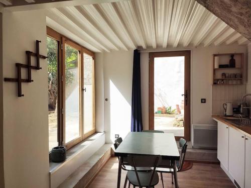 une cuisine avec une table et des chaises et une fenêtre dans l'établissement Studio aux Arceaux, sur jardin, dans maison 1900, à Montpellier