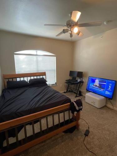 1 dormitorio con 1 cama y TV de pantalla plana en Make it your own!(Willow Bend), en Plano