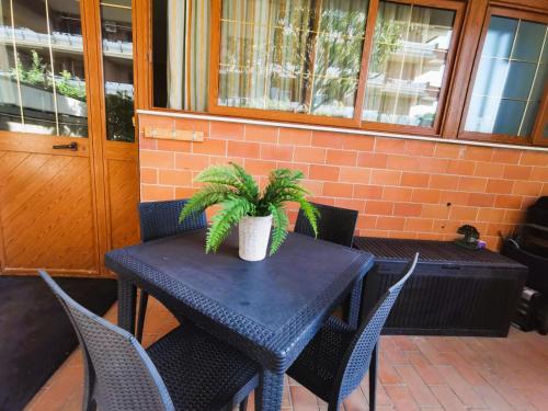 une table noire avec des chaises et une plante sur elle dans l'établissement OSTIA HOME, à Lido di Ostia