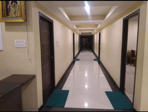 an empty corridor in a building with a long hallway at Vinayagam Residency in Arcot