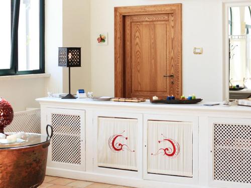 a white cabinet with red arrows on it in a room at Hotel Giardino Giamperduto in Bernalda