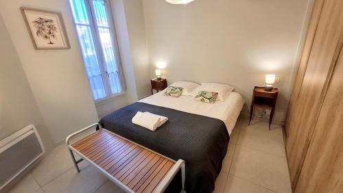 une petite chambre avec un lit et une table dans l'établissement Ze Perfect Place - Charmant appartement - Masséna, à Nice