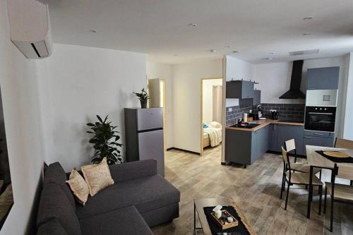 un salon et une cuisine avec un canapé et une table dans l'établissement Appartement Kantar- La dame d'OR, à Anduze