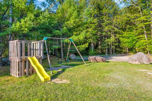 a playground with a slide in the grass at Mersey River Chalets a nature retreat in Caledonia