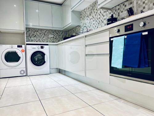 a white laundry room with a washer and dryer at Absolutely Beautiful Hemel Hempstead 2-bedroom for 1-5 Guests - contractors welcome in Hemel Hempstead