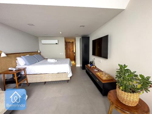 Schlafzimmer mit einem Bett, einem Schreibtisch und einem TV in der Unterkunft Apartamento na Vitória com Pier e acesso ao mar in Salvador