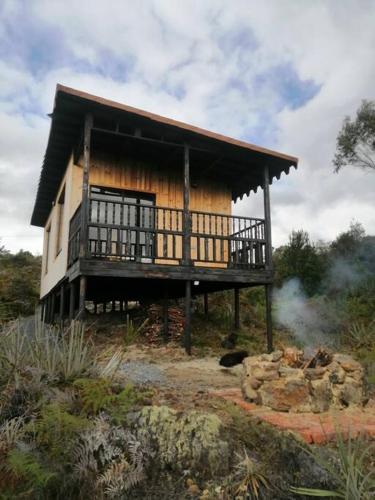 uma casa numa colina com fumo à frente dela em Mountain Glamping - Nature and Relax em Fúquene