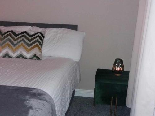 a bedroom with a bed and a table with a lamp at Dún Eoin Carrigaline in Carrigaline