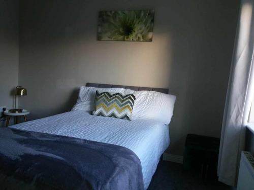 łóżko z niebieską kołdrą i poduszkami w sypialni w obiekcie Dún Eoin Carrigaline w mieście Carrigaline