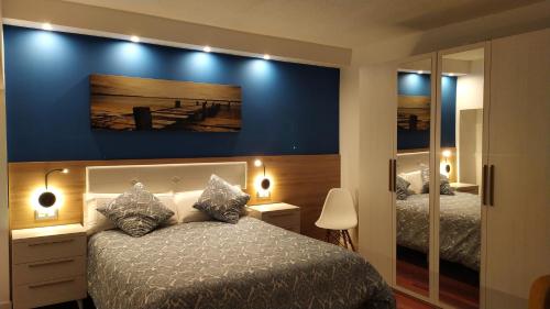 ein Schlafzimmer mit 2 Betten und einer blauen Wand in der Unterkunft Apartamento con encanto "ZIRIMIRI" in Bermeo