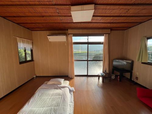 a bedroom with a bed and a tv and a window at Guest house HEART - Vacation STAY 04732v in Hitoyoshi