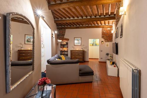 sala de estar con espejo y sofá en Apartment Anfiteatro en Lucca