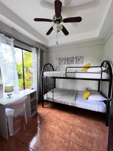 a bedroom with two bunk beds and a ceiling fan at Hotel Villas de la Colina in Atenas