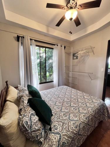 a bedroom with a bed and a ceiling fan at Hotel Villas de la Colina in Atenas