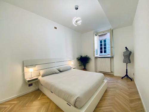 um quarto branco com uma cama grande e uma janela em WANDERLUST Splendido appartamento in centro em Pavia