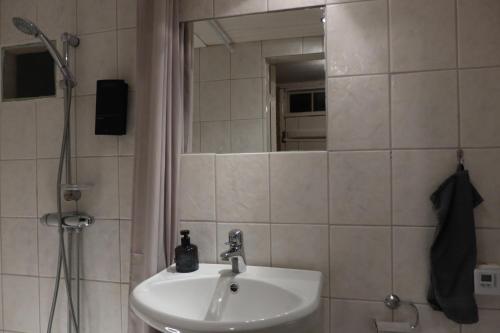 W łazience znajduje się umywalka oraz prysznic z lustrem. w obiekcie Remarkable Harbour View Cabin. w mieście Östhammar