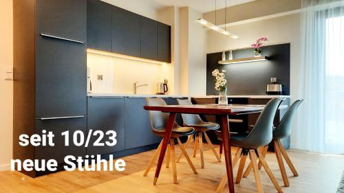 een keuken met een tafel en stoelen in een kamer bij Ferienwohnung A102 mit Komfort in Strandnähe mit Terrasse und Meerblick in 10ter Etage PARKING FREE in Międzyzdroje