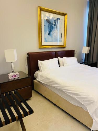 a bedroom with a bed and a picture on the wall at Hill Top Holiday Homes Rental in Dubai