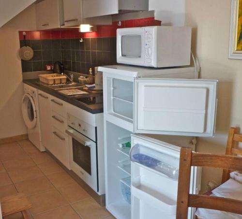 La cuisine est équipée d'un four micro-ondes et d'un réfrigérateur ouvert. dans l'établissement Beau F2 rdc entier 40m2 calme terrasse jardin parking gratuit sur place, à Montpellier