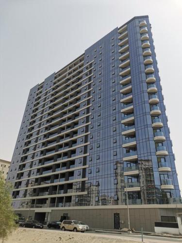 a large building with cars parked in front of it at Hill Top Holiday Homes Rental in Dubai