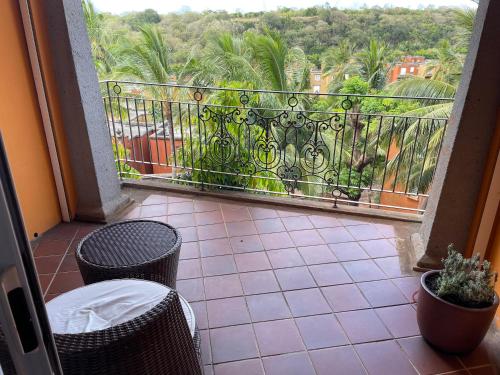 a balcony with a wrought iron railing and palm trees at Charming 2-Bedroom Ensuite Villa in picturesque Port Chambly in Terre Rouge