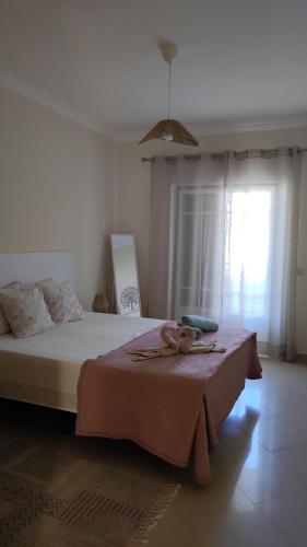 a bedroom with a bed with a teddy bear on it at Casa Brisa do Mar in Porches