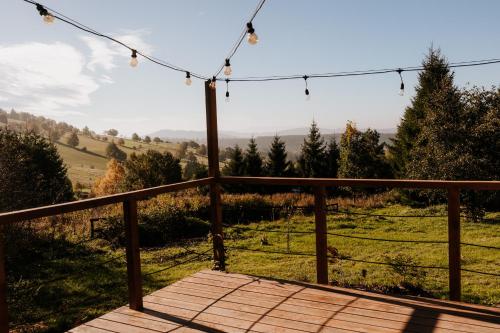 a wooden deck with a view of a field at Bohema in Sierpnica