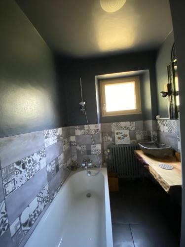 ein Badezimmer mit einer Badewanne und einem Waschbecken in der Unterkunft Les gîtes du Poten'ciel, idéal famille, Bien-être, Massages in Allègre