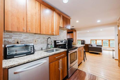 a kitchen with a sink and a microwave at Private estate apartment. in Glen Head