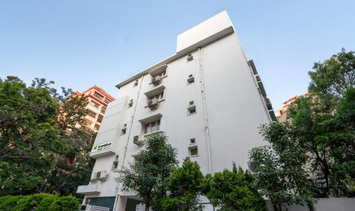 a white building with trees in front of it at Treebo Trend Emerald in Hyderabad