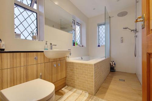 een badkamer met een wastafel, een toilet en een bad bij The Wendy House in Bournemouth
