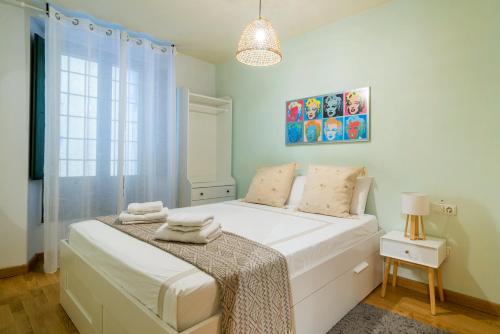 Un dormitorio con una gran cama blanca en una habitación. en Elena Apartments - Girona, en Girona