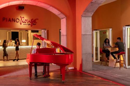 a boy playing a red piano in a building at Charming 2-Bedroom Ensuite Villa in picturesque Port Chambly in Terre Rouge