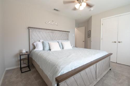 a bedroom with a large bed with white sheets and pillows at Texas Roots: King Beds and Modern Comfort in McKinney