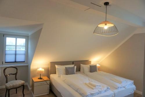 a bedroom with a bed with a lamp and a chair at Lerchenhof - Haus Wiesengrund in Reestow