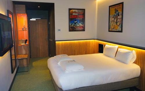 a bedroom with a large bed with white sheets at Kyriad Clermont Ferrand Nord - Riom in Riom