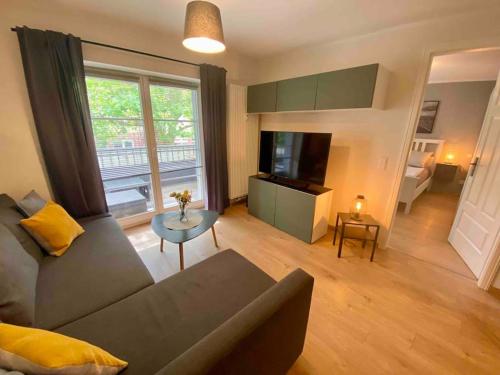 ein Wohnzimmer mit einem Sofa, einem Tisch und einem TV in der Unterkunft Apartment in Potsdam-Babelsberg in Potsdam