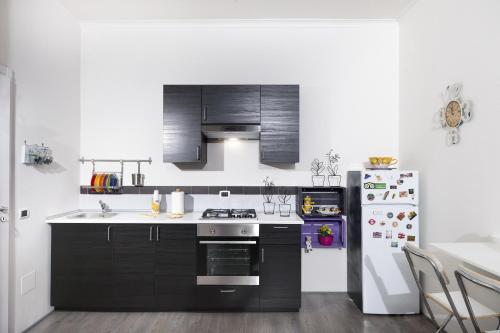 a kitchen with black cabinets and a refrigerator at B&B Sleep & Zupp in Naples
