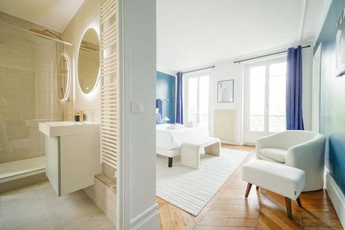 a bathroom with a white sink and a white chair at Charmant Appartement proche de L'Opéra Bastille - III in Paris