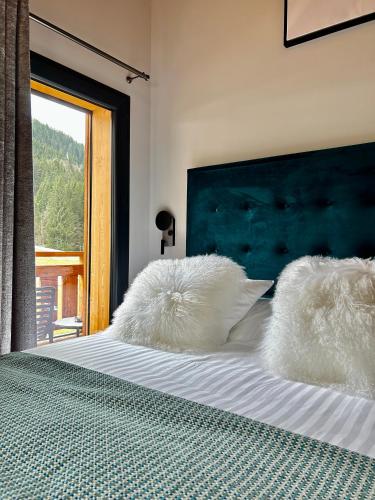 a bed with white pillows on it with a window at Hameau des Prodains - Résidence in Morzine